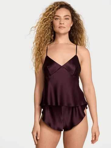 Front view of a woman wearing Victoria's Secret black transparent babydoll on a light grey background.